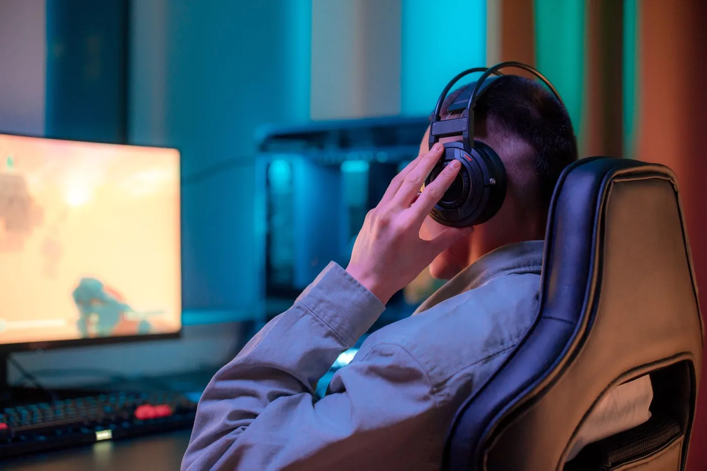 Gamer wearing headphones at a desktop setup